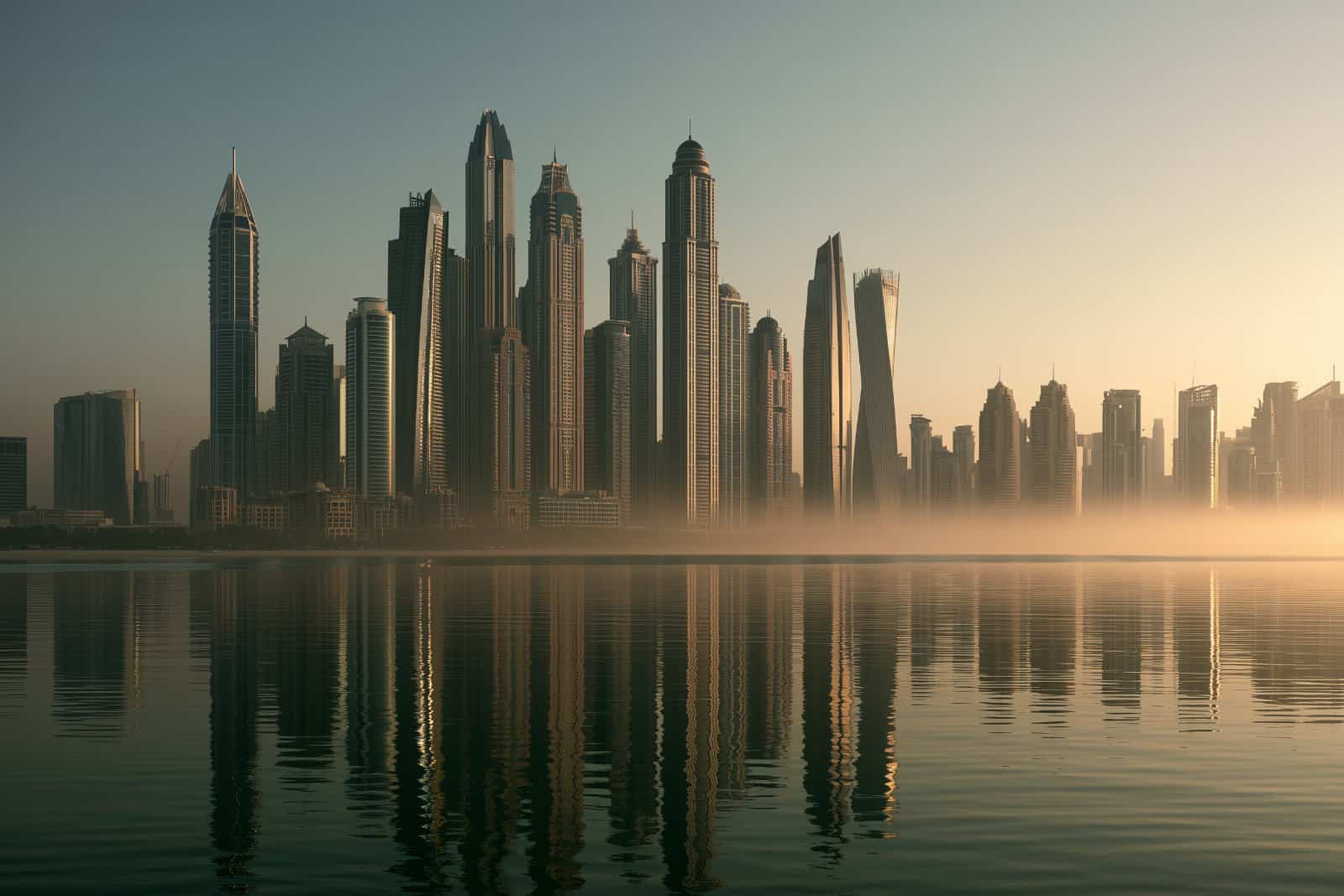 Dubai marina skyline across calm water at dawn